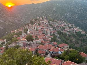una ciudad en la cima de una montaña con la puesta de sol en Traditional stone house - Dimitsana, en Dhimitsana