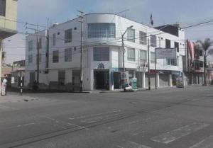 a white building on the side of a street at APARTAHOTEL CASA REAL tacna in Tacna
