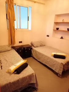 a room with two beds and a window at Banana Beach Flat in Agadir