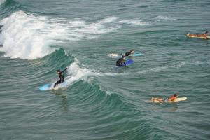 a group of people riding a wave on surfboards in the ocean at Banana Beach Flat in Agadir +9 photos