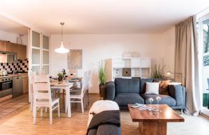 a living room and kitchen with a couch and a table at Parkside Apartment House in Düsseldorf