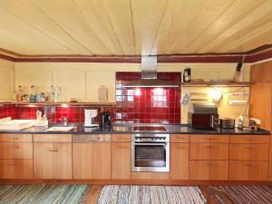 a large kitchen with wooden cabinets and red tiles at Haus Völlegg in Völlegg