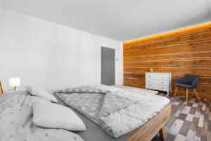 a bedroom with a large bed and a wooden wall at U Lokajů in Rašovice