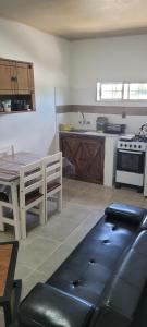 a kitchen with a table and a stove and a table and a table sidx sidx at Apartamento Romian Román in Paysandú