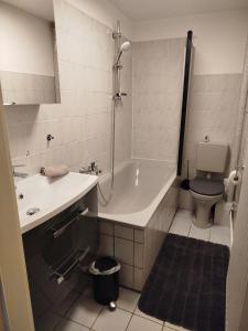 a bathroom with a tub and a toilet and a sink at Ferienwohnung Harz in Ballenstedt in Ballenstedt