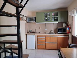 a kitchen with green cabinets and a white refrigerator at La Esquina in Esquel