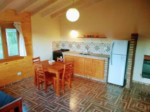 a kitchen with a wooden table and a refrigerator at Cabaña Los Chochos in Lago Puelo