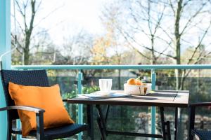 una mesa con una taza de café y naranjas en el balcón en Parkside Apartment House, en Düsseldorf