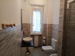 a bathroom with a toilet and a sink and a window at Eros casa in Milan +7 photos