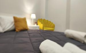 a bedroom with a bed and a yellow chair at Le Popolari - Appartamento in Bitonto +19 photos
