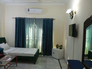 Una pequeña habitación con una cama y una ventana. en Orion International Guest House, en Islamabad