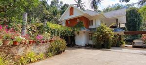 a house with plants and flowers in front of it at Nadackal Nature County in Munnar