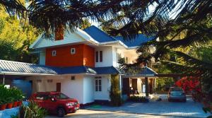 a house with a red car parked in front of it at Nadackal Nature County in Munnar