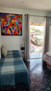Un dormitorio con una cama y un cuadro en la pared. en Casita da barra, en Búzios