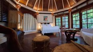 a bedroom with a white bed in a room with windows at Jungle Cocoon Boutique Hotel in Caye Caulker