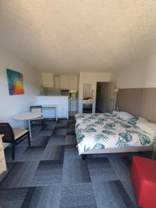 a bedroom with a bed and a table and a kitchen at Studio Golf&Plage Chiberta in Anglet