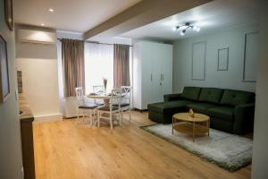 a living room with a green couch and a table at Nova Studio Apartments in Reghin