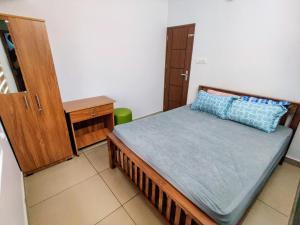 ein Schlafzimmer mit einem Bett mit einem blauen Kissen darauf in der Unterkunft The Vagabond Stays in Vagamon