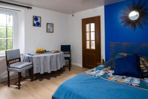 een slaapkamer met een bed, een tafel en een spiegel bij Chambres d'Hôtes La Petite Odile in Boersch