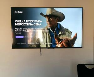 a flat screen tv hanging on a wall at Rynek 23 LUX, apartament z widokiem na ratusz , parking free pod domem in Gliwice