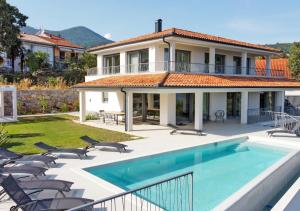 a house with a swimming pool and some chairs at Villa Maritima Opatija-Meerblick-Infinity Pool-Luxus-Relax in Opatija