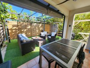 an outdoor patio with a wooden table and chairs at Zion Appartement SXM in Orient Bay