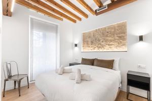 a white bedroom with a large bed and a chair at Palacio Sempere in Alicante