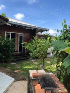 クチンにあるSri Kandis Cottage Stayの庭前の焼き家