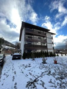 un grande edificio con la neve davanti di Moolys place a Buşteni