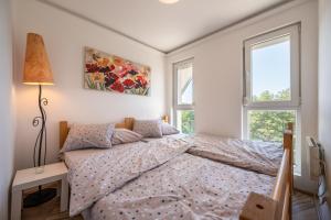 a bedroom with a bed and two windows at Apartman Senka 2 in Divčibare