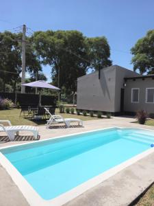 a swimming pool with chairs and a house at Casa de los Cerros I - Vaqueros in Vaqueros