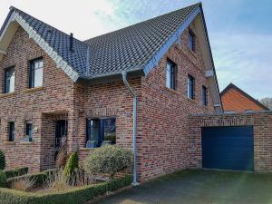 a brick house with a blue garage door at JOOYFUL STAYS Cozy Home in Kevelaer