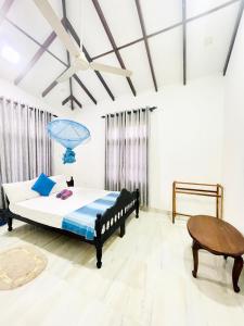 a bedroom with a bed and a table at Sebastian Family Villa in Negombo