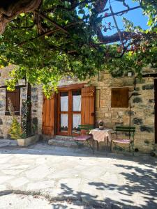 ein Tisch und Stühle vor einem Gebäude in der Unterkunft Eleni's Cottage in Apsiou