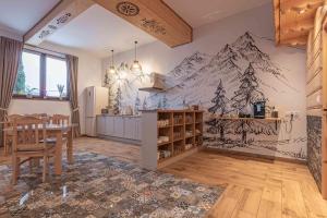 a kitchen with a table and a mountain mural on the wall at Goralove Pole in Brzegi