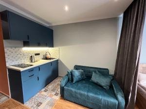 Una sala de estar con un sofá y una cocina. en Cozy apartment in NEW GUDAURI Block F2, en Gudauri