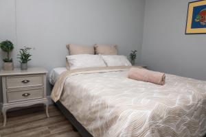 a bedroom with a bed and a nightstand with a bed sidx sidx at Stylish and Modern Oasis in Windhoek +13 photos