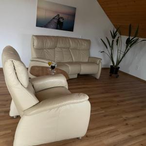 a living room with a white couch and a chair at Orchidee in Dinkelsbühl