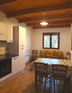 a kitchen and a dining room with a table and chairs at La Ripa Del Drago in Bibbona