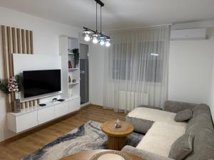 a living room with a couch and a tv at Smart Apartmani in Kruševac