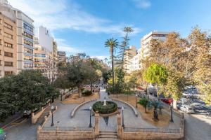 a park in a city with a fountain and buildings at Palacio Sempere in Alicante