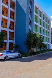 a white car parked in front of a building at Haydenco Suites Signatuture Mall Syokimau in Nairobi +3 photos