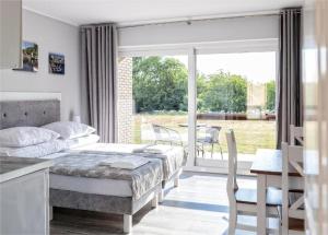 スヴァネケにあるBornholm Apartmentsのベッドとテーブルと椅子のある寝室