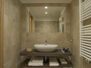 
a bathroom with a sink and a bath tub at Hotel Garnì Caminetto in Madonna di Campiglio
