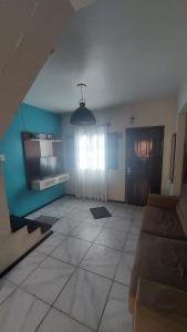 a living room with a couch and a window at Aluguel Temporada Oliveira e Santos in Arroio do Sal