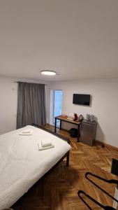 a room with a bed and a table and a television at DreamPlace Airport & Therme 3 in Otopeni