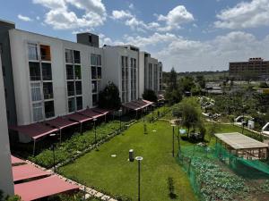 an apartment complex with a lawn in front of a building at Haydenco Suites Signatuture Mall Syokimau in Nairobi