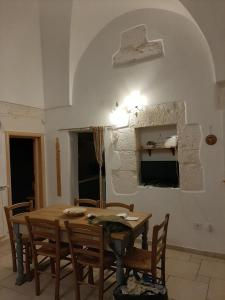 Un comedor con mesa y sillas de madera. en La perla bianca, en Ostuni