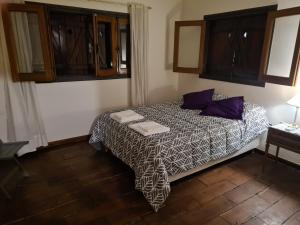 a small bedroom with a bed with purple pillows at LA CASA de la ALEM 1 in La Rioja