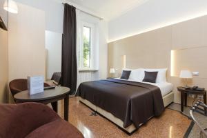 a hotel room with a bed and a chair at Domus Terenzio in Rome
